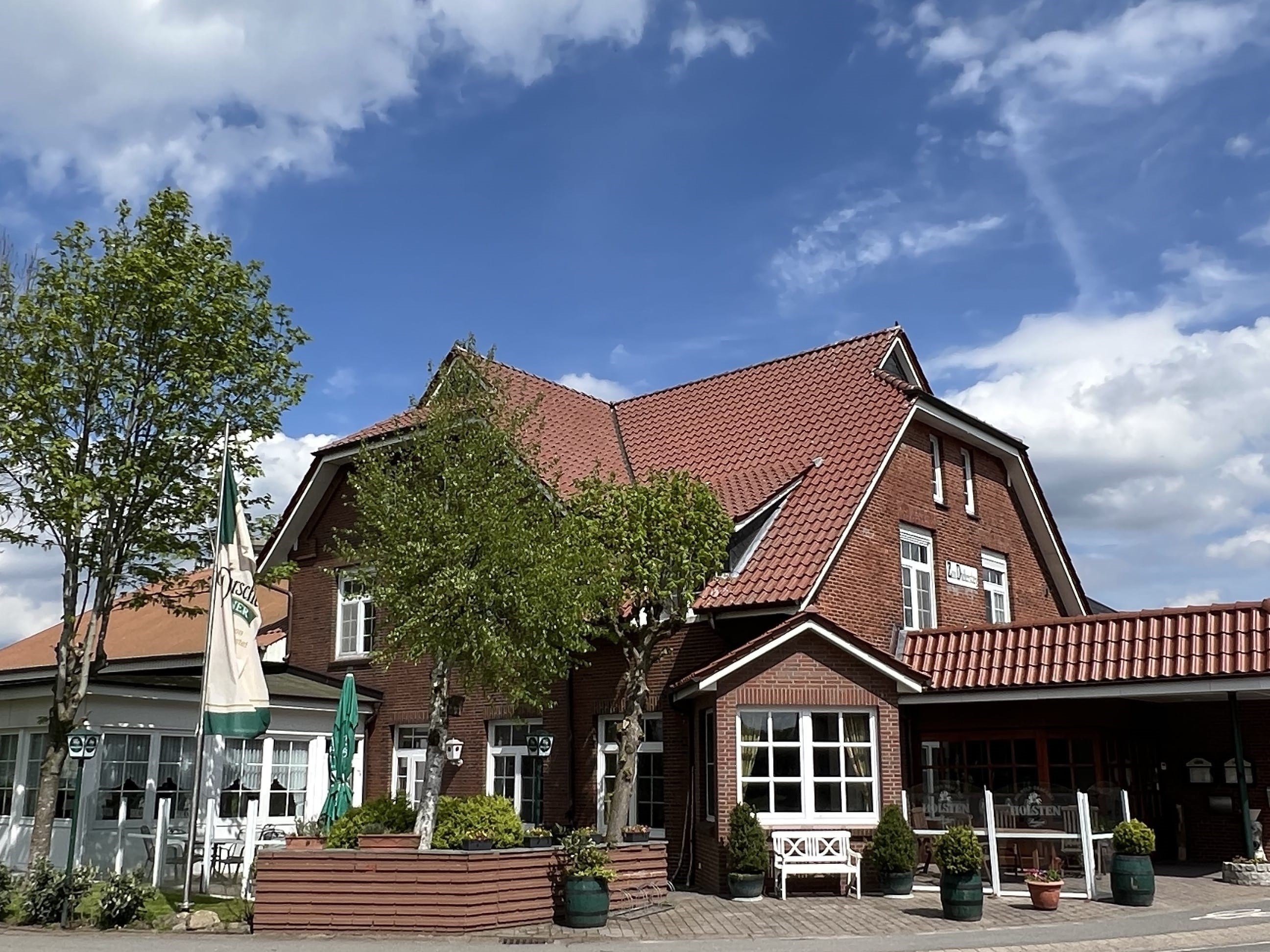 Restaurantgebäude mit blauem Himmel und Dithmarscher Fahne davor.