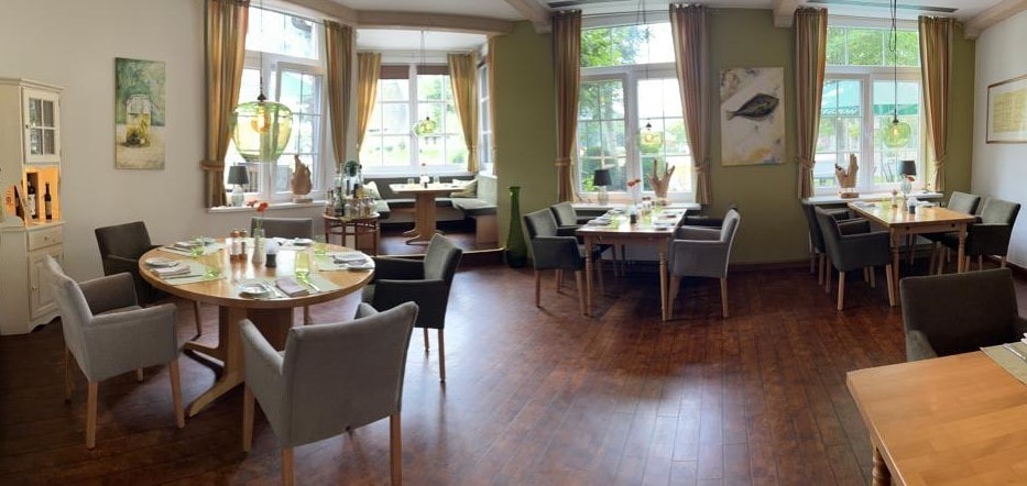Restaurant von Innen mit grünen Wänden und Lampen